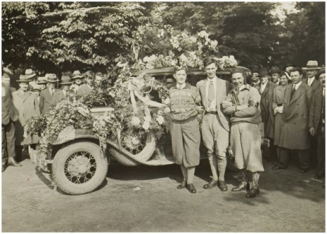 Op de foto zien we voor de auto links Jan van Abbe met zijn miniatuur Tiroler hoedje met krulveer, rechts Jacques van der Meulen met rode Montenegrijnse muts. Tussen hen in verslaggever Went.